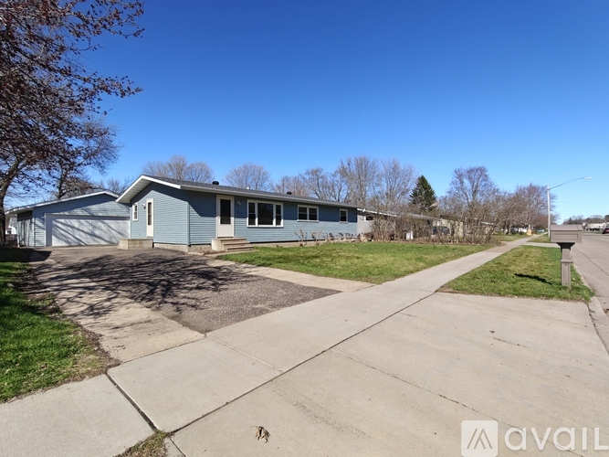 A blue house with a white door and windows is for sale.