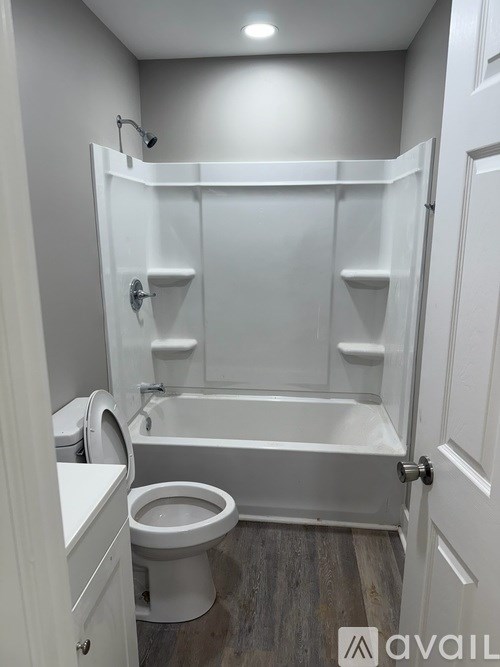 A white bathroom with a toilet, tub, and shower.