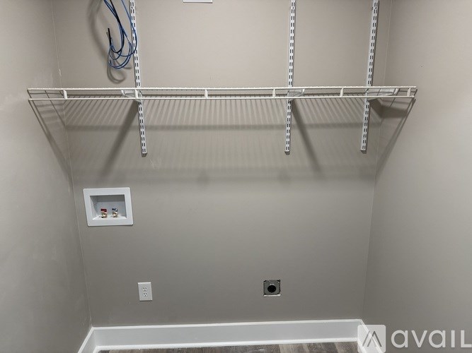 A white shelving unit with a white box on the wall.