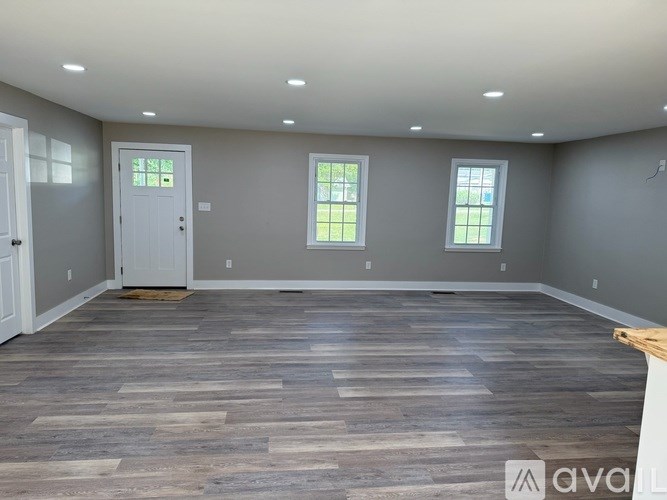 A room with wooden flooring and a white door.