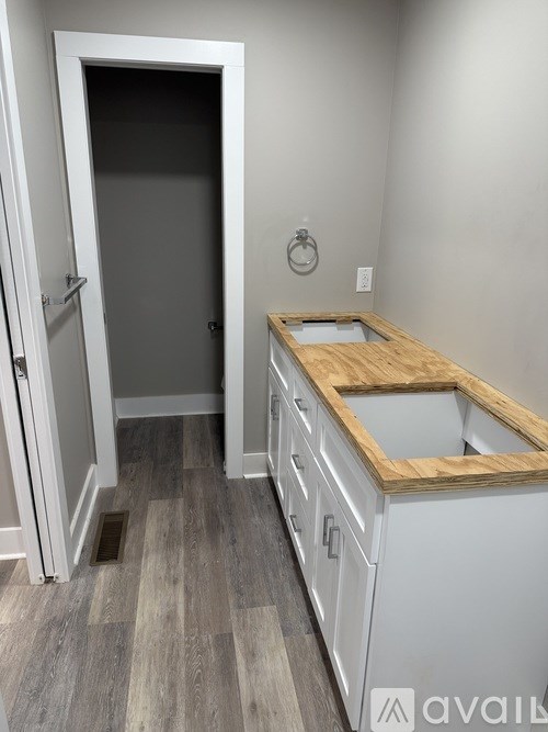 A kitchen with a white cabinet and a wooden counter top.