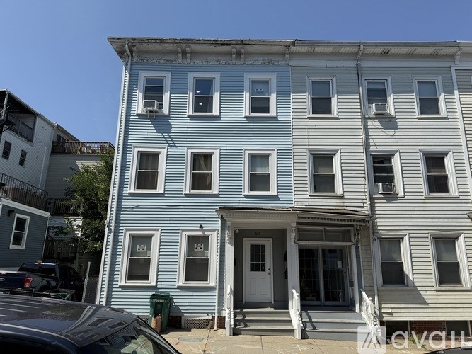 A blue and white two story building with a car parked in front.