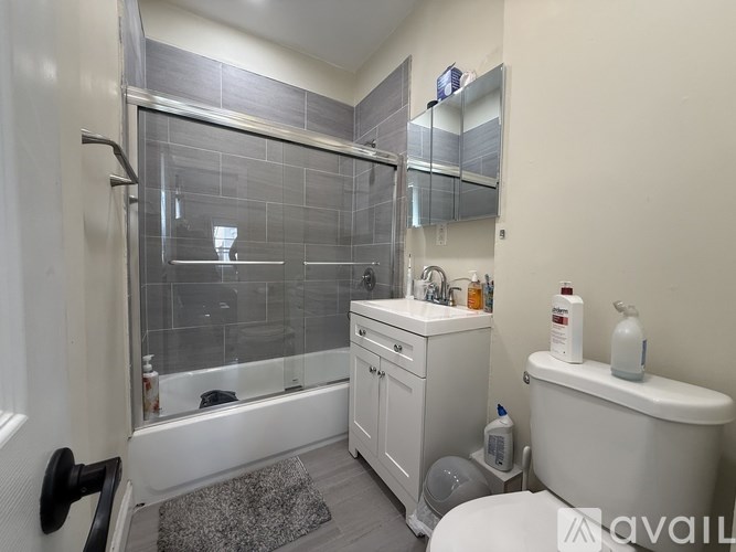 A bathroom with a white tub, sink, and toilet.