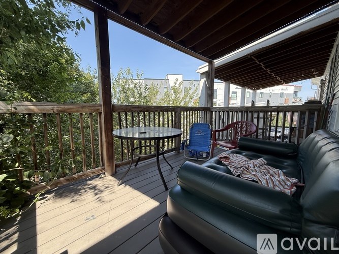 A balcony with a black leather sofa and a round table.