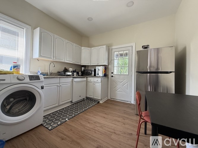 A kitchen with white cabinets and a washing machine.