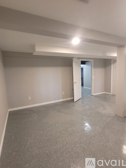 A spacious room with a grey floor and white walls.