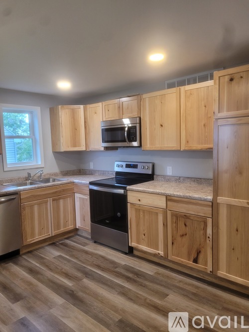 A kitchen with wooden cabinets and a black stove top oven.