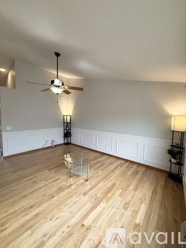 A room with wooden flooring and a ceiling fan.
