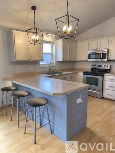 A kitchen with a bar area and a stove top oven.