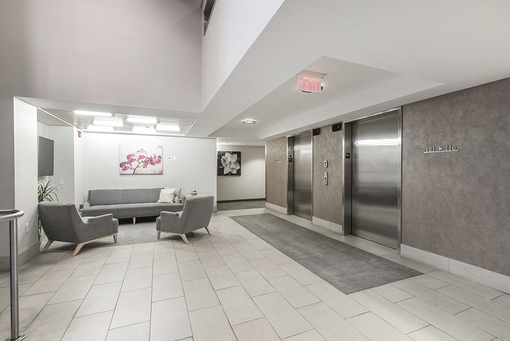 a lobby with couches and elevators and a hallway with doors