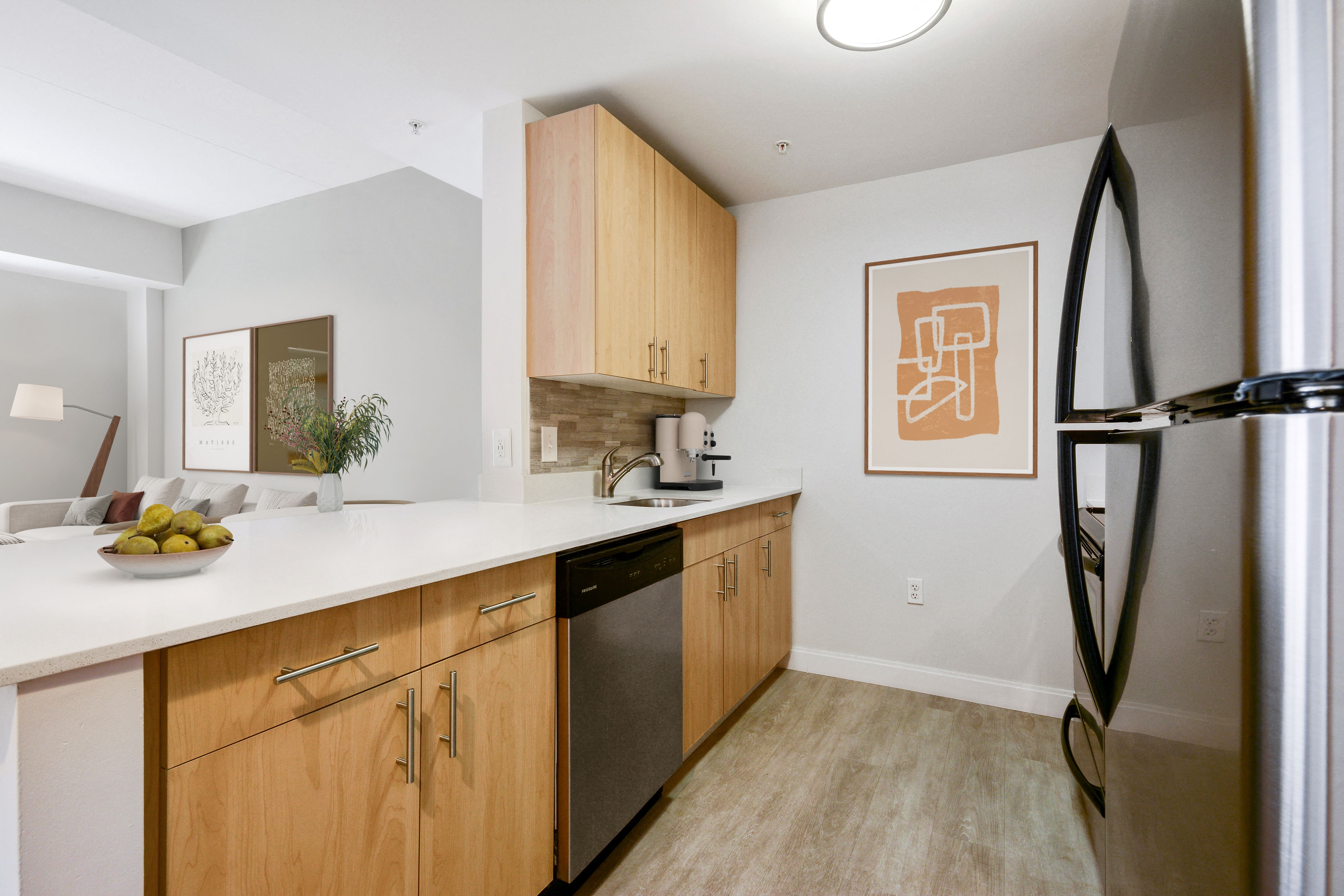 A kitchen with wooden cabinets and a fridge.