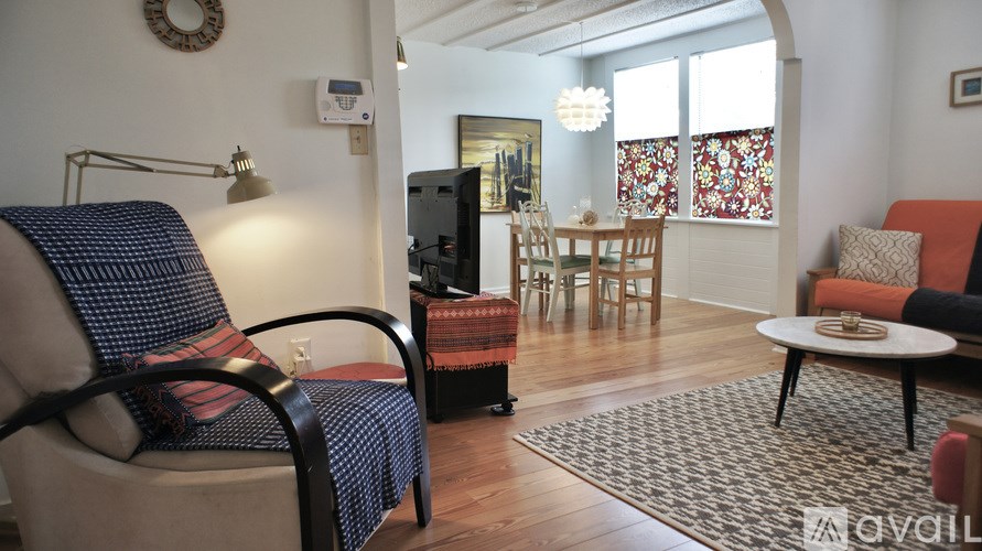 A living room with a sofa, chairs, and a television.