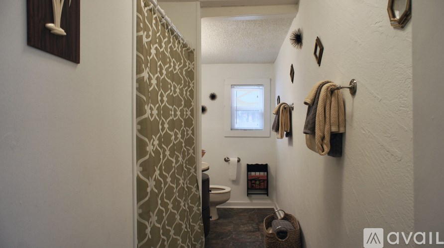 A bathroom with a toilet, a mirror, and a towel rack.