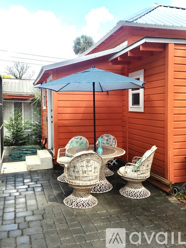 A patio with a table and chairs under an umbrella.