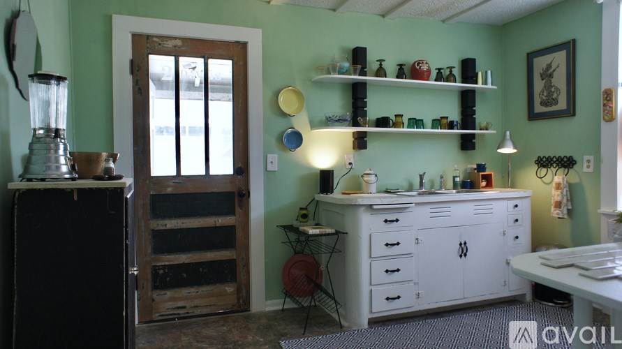A kitchen with green walls and a white cabinet.