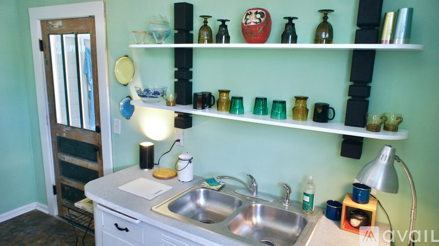 A kitchen with a sink and a counter with a few items on it.