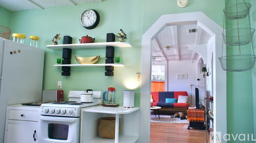 A kitchen with a white stove and green walls.
