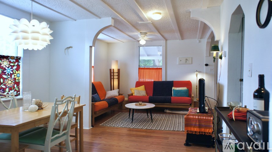 A living room with a couch, chairs, and a table.