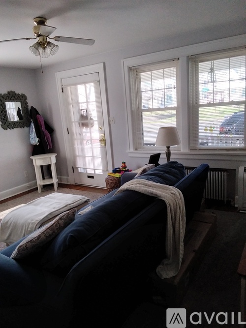 A living room with a dark blue couch and a white side table.