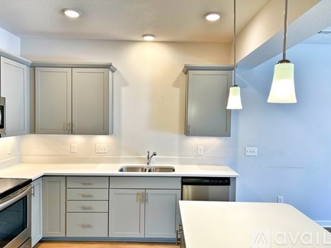 A modern kitchen with white cabinets and a large island.