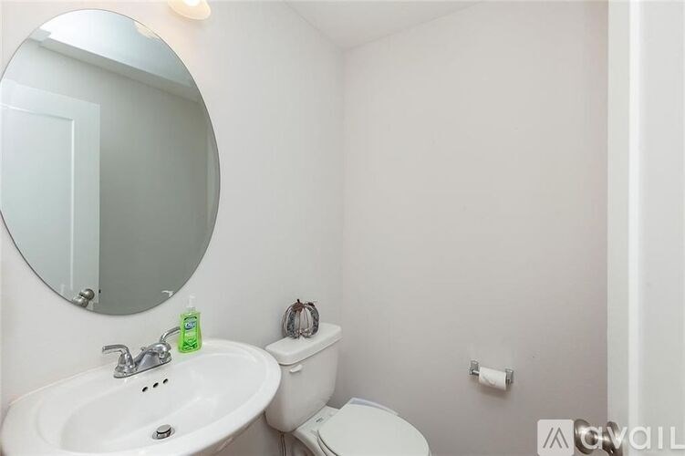 A bathroom with a white toilet, sink, and mirror.