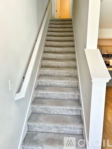 A staircase with a carpeted runner and white balusters.