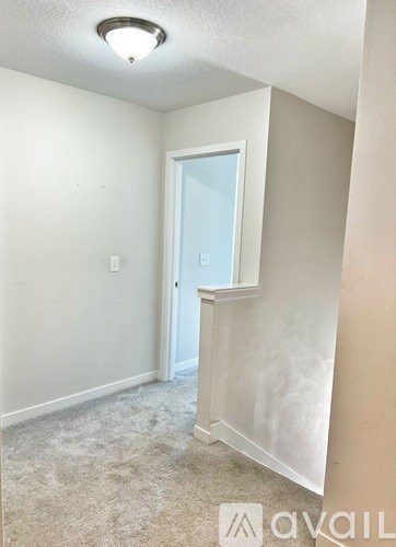 A room with a carpeted floor and a door leading to a balcony.