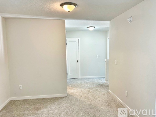 A room with a carpet floor and a door in the background.