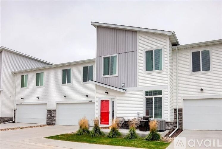 A modern house with a red door and two garages.