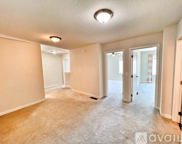 A room with beige carpet and white walls is available for rent.