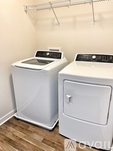 Two white front loading washing machines in a laundry room.
