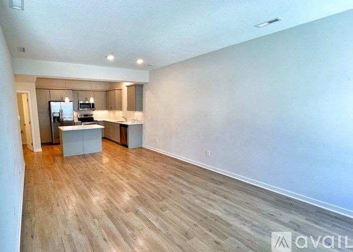 A spacious living area with a kitchen in the background.