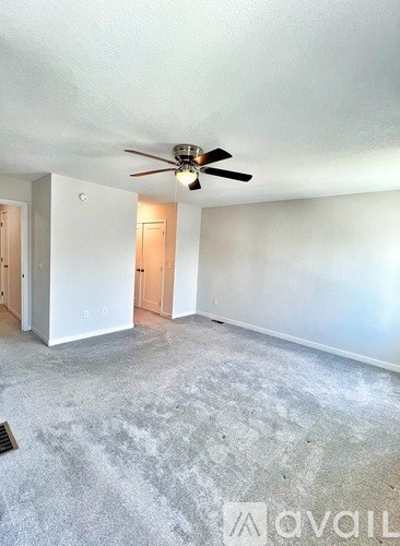 A room with a ceiling fan and a concrete floor.