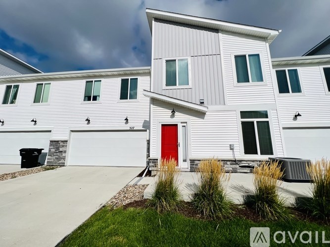 A white house with a red door and a garage.