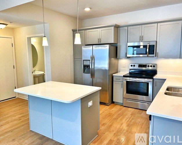 A modern kitchen with stainless steel appliances and a central island.