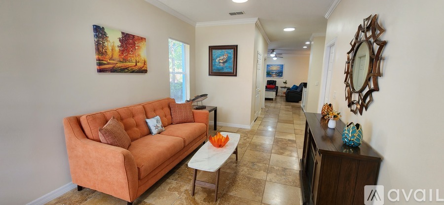 A living room with a couch, a coffee table, and a painting on the wall.
