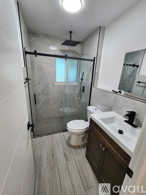 A bathroom with a toilet, sink, and walk-in shower.
