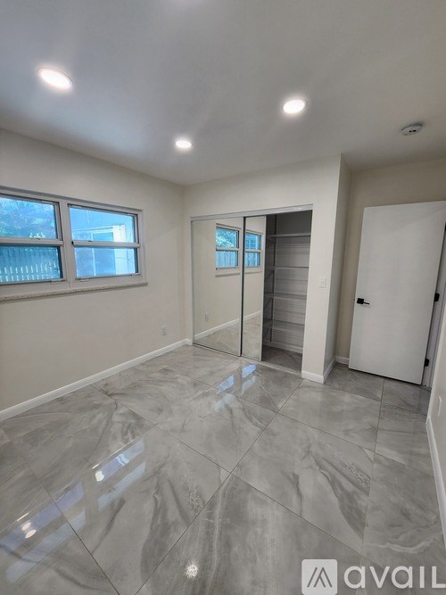 A room with a marble floor and a door leading to a hallway.