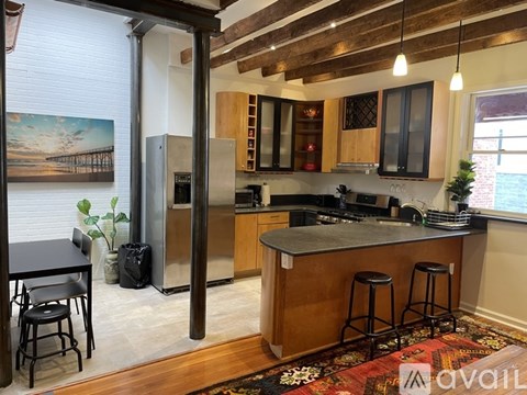 A kitchen with a wooden floor and a large island in the middle.