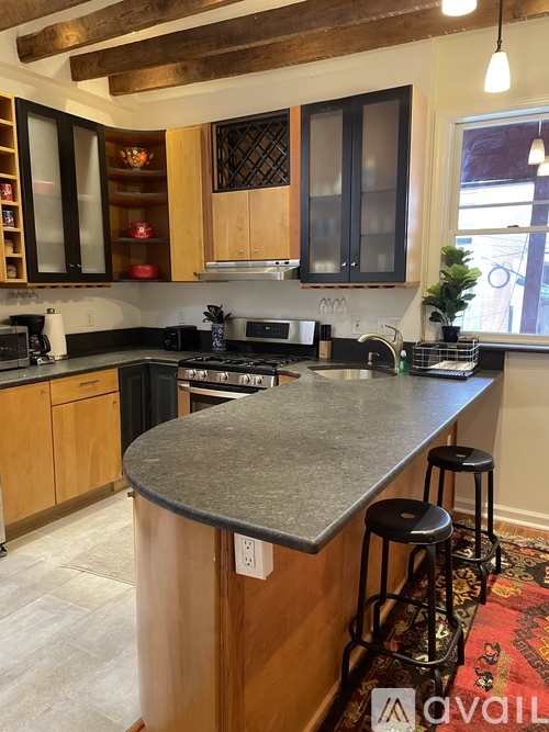 A kitchen with a granite countertop and wooden cabinets.