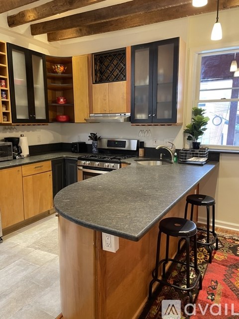 A kitchen with a granite countertop and wooden cabinets.