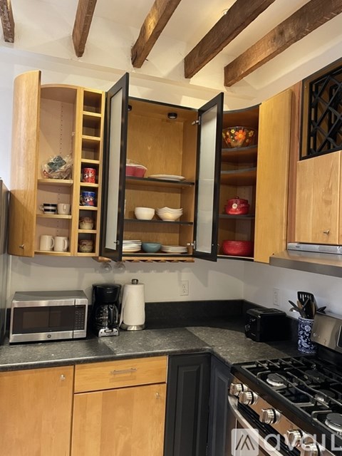 A kitchen with wooden cabinets and a black stove top.