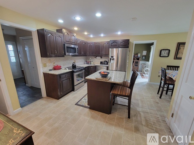 A kitchen with brown cabinets and a tile floor.