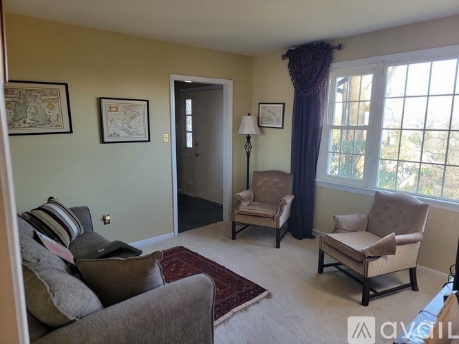 A living room with a grey couch, a chair, and a small table.