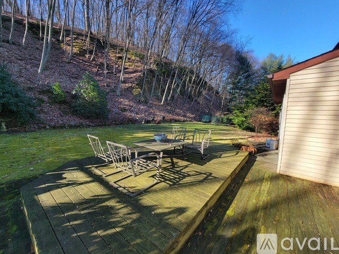 A backyard with a wooden deck and a table set up for outdoor dining.