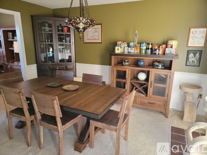 A wooden dining table with chairs and a chandelier in a room.