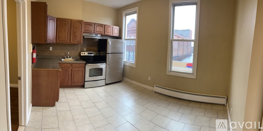 A kitchen with a refrigerator, oven, and sink.