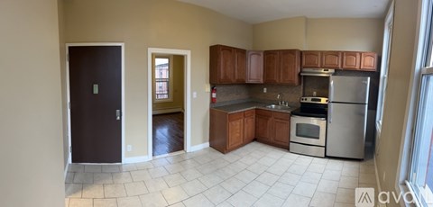 A kitchen with wooden cabinets and a stainless steel refrigerator.