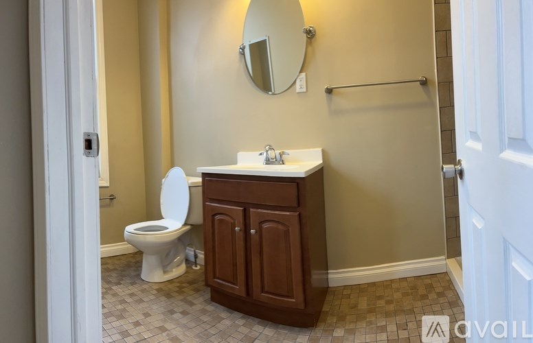 A bathroom with a toilet, sink, and mirror.