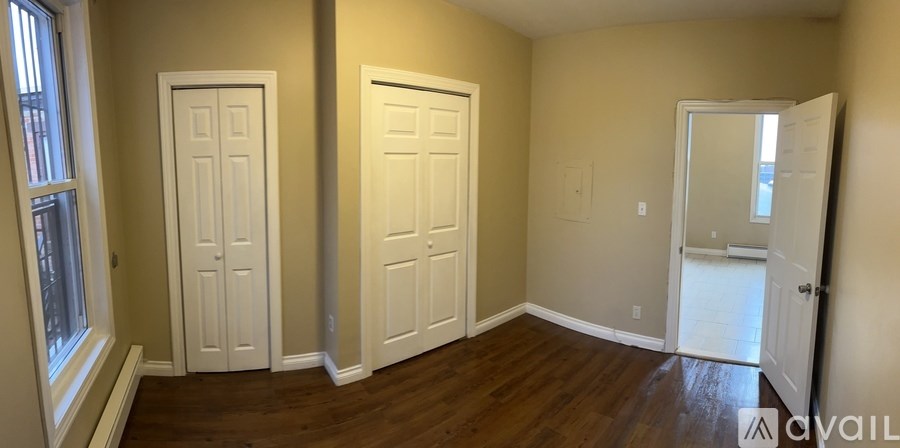 A room with three white doors and a window.